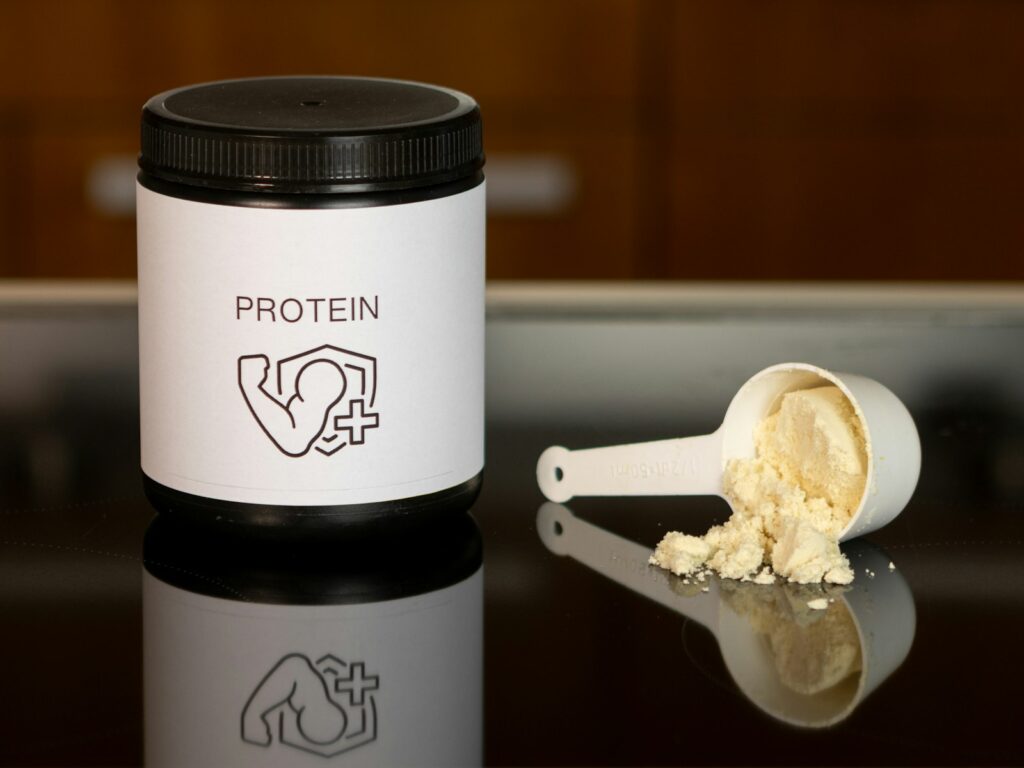 A supplement powder container and scoop, representing creatine supplementation