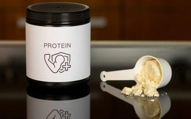 A supplement powder container and scoop, representing creatine supplementation