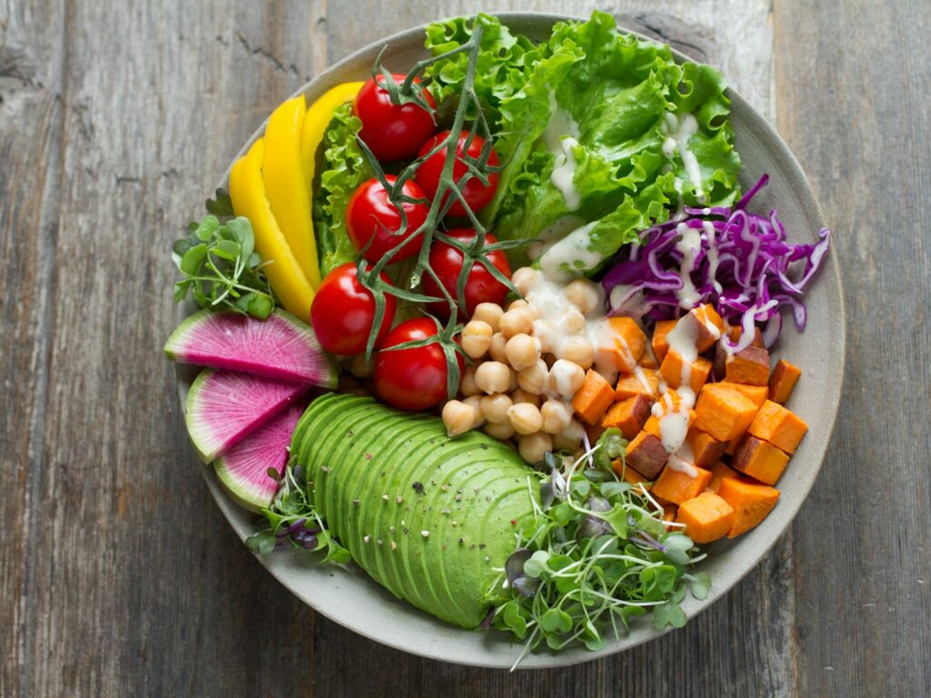 A colorful vegan salad bowl with vegetables, chickpeas, and sweet potato